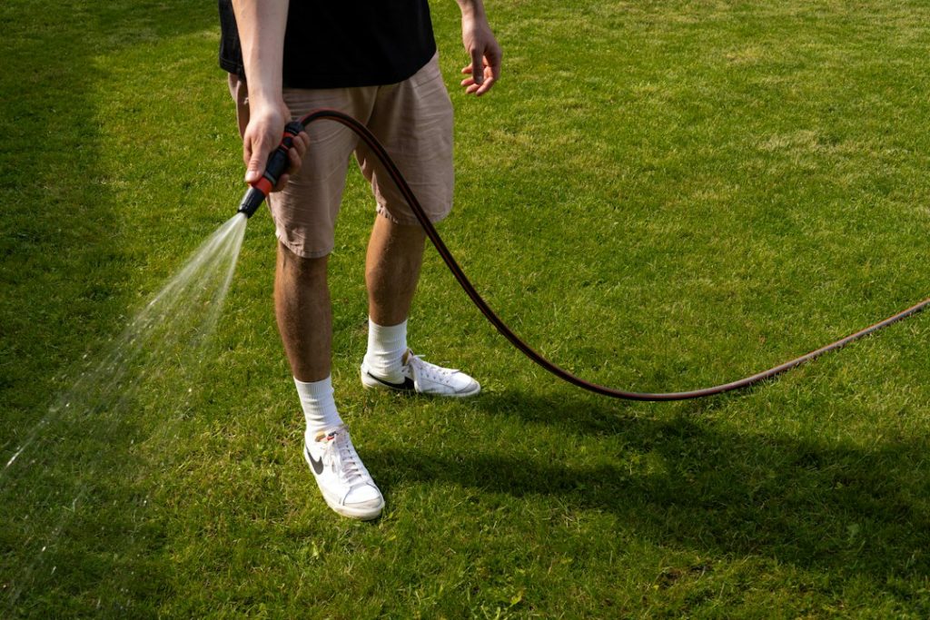 Homeowner inspecting lawn watering before calling for sprinkler repair