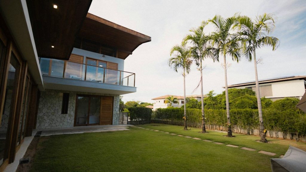 Modern home and lawn representing smart irrigation technology and traditional sprinkler scheduling