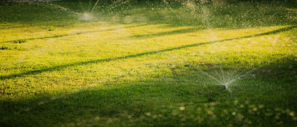 Residential sprinklers watering a lawn during low-pressure valve troubleshooting