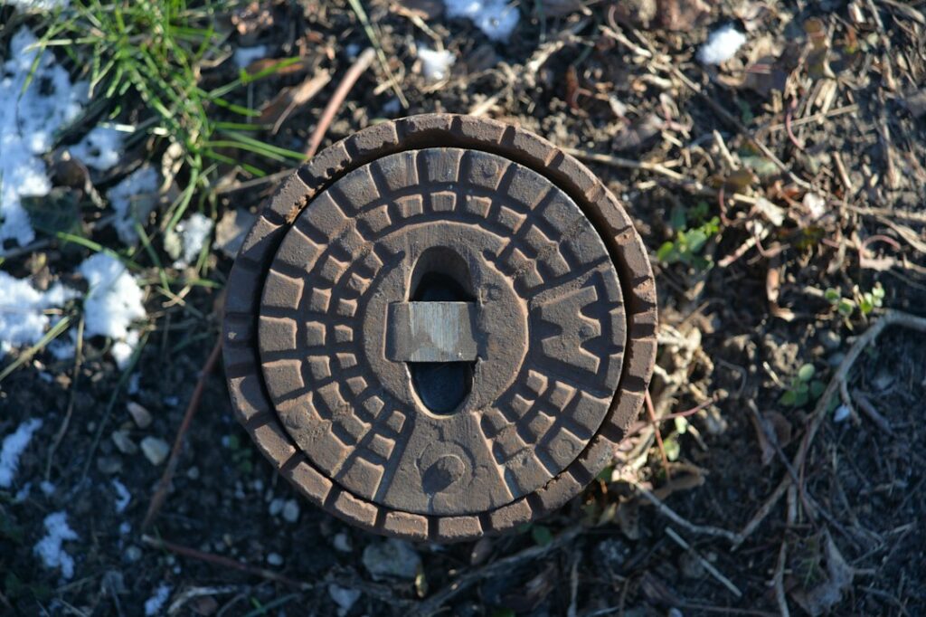 Covered ground access point illustrating the challenge of locating a buried sprinkler valve